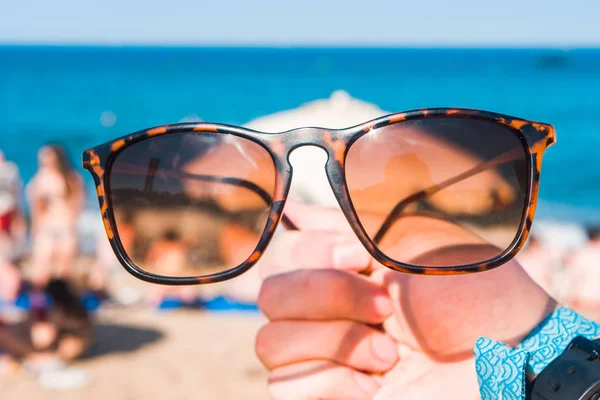 Occhiali Sole Una Mano Sulla Spiaggia Giornata Estiva Lucente — Foto Stock