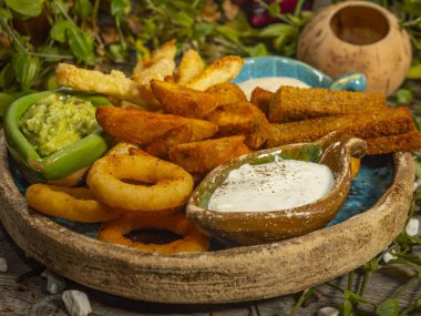 Bira için abur cubur tabağı. Patates kızartması, peynir çubuğu, soğan halkası ve beyaz sos