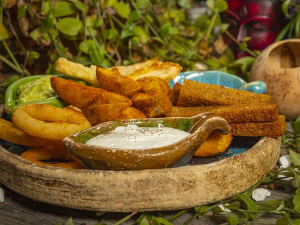Bira için abur cubur tabağı. Patates kızartması, peynir çubuğu, soğan halkası ve beyaz sos — Stok fotoğraf