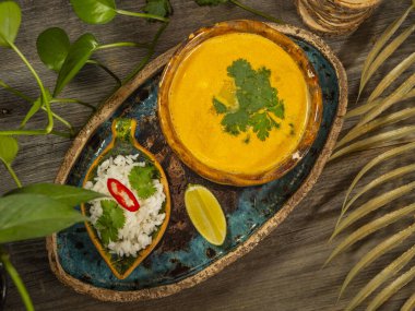 Bir tabak lezzetli balkabağı çorbası, bir porsiyon otlu pirinç ve bir dilim limon. El sanatları yemeklerinde