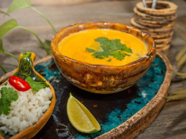 Bir tabak lezzetli balkabağı çorbası, bir porsiyon otlu pirinç ve bir dilim limon. El sanatları yemeklerinde