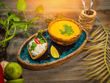 Bir tabak lezzetli balkabağı çorbası, bir porsiyon otlu pirinç ve bir dilim limon. El sanatları yemeklerinde