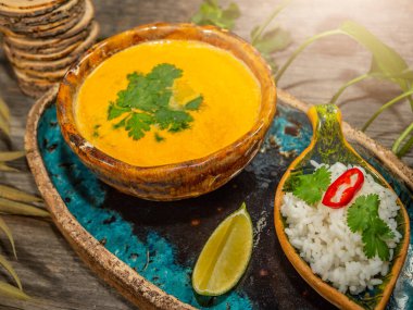 Bir tabak lezzetli balkabağı çorbası, bir porsiyon otlu pirinç ve bir dilim limon. El sanatları yemeklerinde