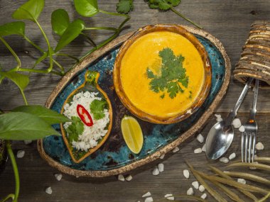 Bir tabak lezzetli balkabağı çorbası, bir porsiyon otlu pirinç ve bir dilim limon. El sanatları yemeklerinde