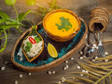 Bir tabak lezzetli balkabağı çorbası, bir porsiyon otlu pirinç ve bir dilim limon. El sanatları yemeklerinde