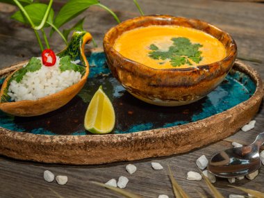 Bir tabak lezzetli balkabağı çorbası, bir porsiyon otlu pirinç ve bir dilim limon. El sanatları yemeklerinde