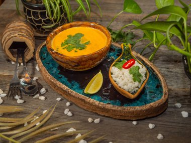 Bir tabak lezzetli balkabağı çorbası, bir porsiyon otlu pirinç ve bir dilim limon. El sanatları yemeklerinde