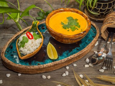 Bir tabak lezzetli balkabağı çorbası, bir porsiyon otlu pirinç ve bir dilim limon. El sanatları yemeklerinde