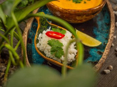 Bir tabak lezzetli balkabağı çorbası, bir porsiyon otlu pirinç ve bir dilim limon. El sanatları yemeklerinde