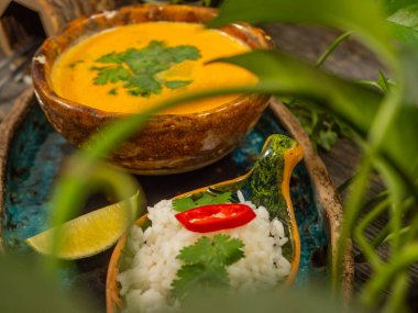 Bir tabak lezzetli balkabağı çorbası, bir porsiyon otlu pirinç ve bir dilim limon. El sanatları yemeklerinde