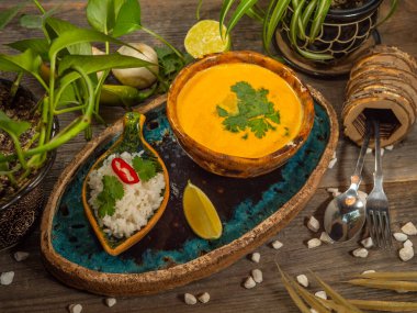 Bir tabak lezzetli balkabağı çorbası, bir porsiyon otlu pirinç ve bir dilim limon. El sanatları yemeklerinde