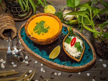 Bir tabak lezzetli balkabağı çorbası, bir porsiyon otlu pirinç ve bir dilim limon. El sanatları yemeklerinde