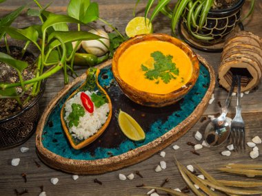 Bir tabak lezzetli balkabağı çorbası, bir porsiyon otlu pirinç ve bir dilim limon. El sanatları yemeklerinde