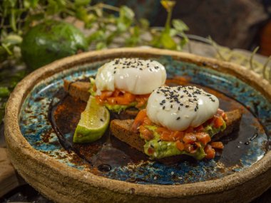 Kırmızı balıklı lezzetli sandviçler ve kızarmış siyah ekmeğin üzerinde guacamole sosu.