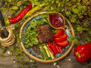 Sebzeli, domatesli ve salatalık dilimlenmiş leziz biftek.