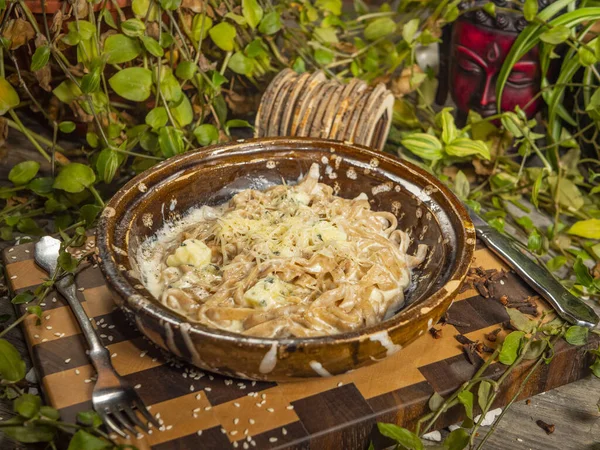 Macarrão de trigo sarraceno delicioso com bacon e frutos do mar em um prato de artesanato — Fotografia de Stock