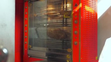 Tavuk bir konveksiyon fırınında pişirilir. Et kırmızı fırının içinde döner..