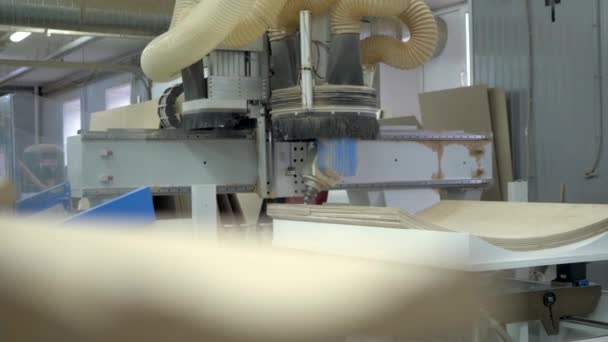 Une grande machine à bois perce des trous dans un produit en bois. Contrôle électronique, production technologique .