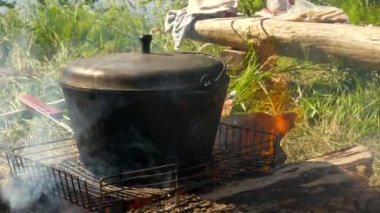 Şöminenin üstünde melon şapka. Piknikte yemek pişirmek. Yürüyüş gezisi. Parlak yaz günü