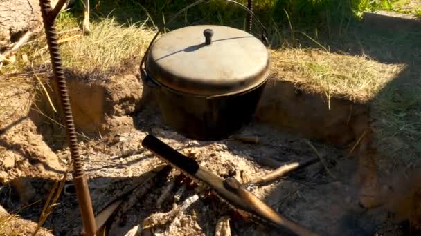 火の上のボウラーの帽子 ピクニックで料理をする ハイキング旅行 明るい夏の日 — ストック動画