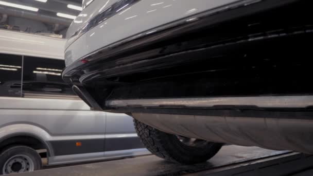 白色的车在汽车服务的电梯上 技术检查和汽车修理 — 图库视频影像