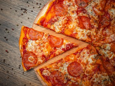 Kafede yırtık pırtık bir yüzeyi olan bir masada nefis lezzetli bir pizza. Sıcak taze pizza.