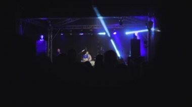 Bir müzik festivalinde dans eden bir kalabalık. Koridorda bir parti var.