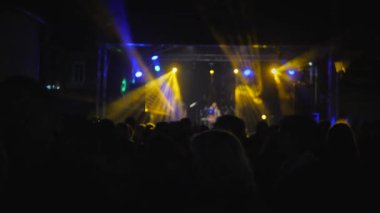 Bir müzik festivalinde dans eden bir kalabalık. Koridorda bir parti var.