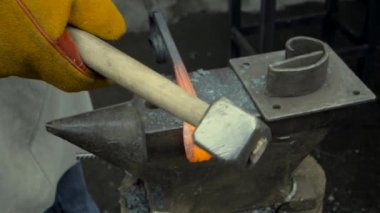 Bir demirci iş başında, sıcak metal dövüyor. Metal Atölyesi