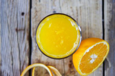 Ahşap masa üzerinde taze sıkılmış portakal suyu bir bardak
