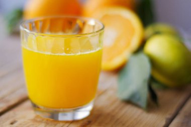 Ahşap masa üzerinde taze sıkılmış portakal suyu bir bardak