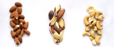 Sağlıklı snack: badem, Brezilya fıstığı ve beyaz arka plan üzerinde kaju fıstığı. İzole, lay düz.