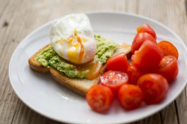 Beyaz plaka üzerinde domates ile avokado Tost üzerinde kızartılmış yumurta