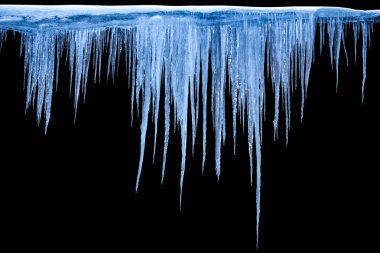 Siyah bir arka plan üzerine buz sarkıtları.