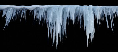 Siyah zemin üzerinde buz saçakları, izole bir nesne. Panoramik fotoğraf.