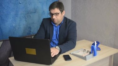 işadamı metin yazarak laptop ile masada oturan gözlüklü