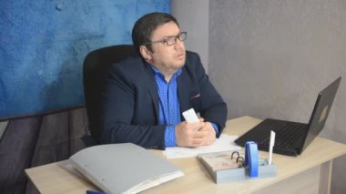 işadamı metin yazarak laptop ile masada oturan gözlüklü