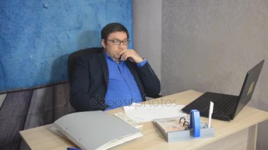 işadamı metin yazarak laptop ile masada oturan gözlüklü