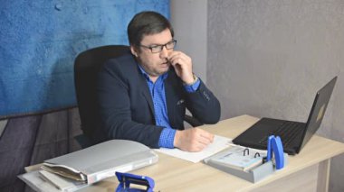 işadamı metin yazarak laptop ile masada oturan gözlüklü