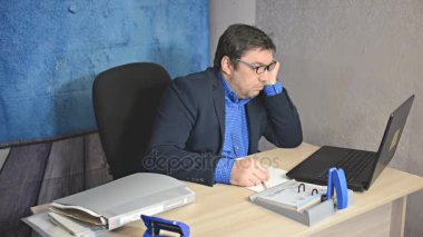 işadamı metin yazarak laptop ile masada oturan gözlüklü