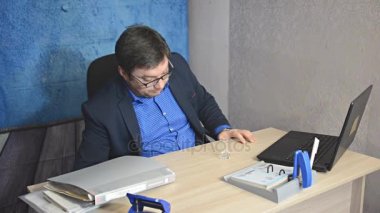 işadamı metin yazarak laptop ile masada oturan gözlüklü