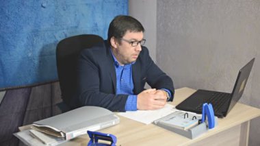 işadamı metin yazarak laptop ile masada oturan gözlüklü