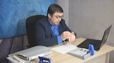işadamı metin yazarak laptop ile masada oturan gözlüklü