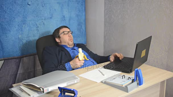 Homme Affaires Chemise Bleue Lunettes Déjeuner Travail Manger Une Banane — Video