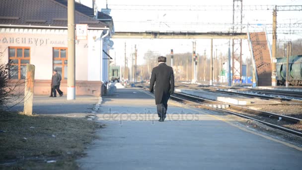 ロシア チャプルイギン チャプルイギン 2018 男が電車を待って駅に向かうプラットフォームに沿って歩く — ストック動画