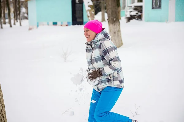 A lány dobja hó a parkban, a fák ellen — Stock Fotó