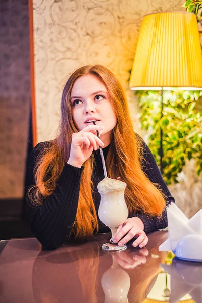 Chica pelirroja bebe un cóctel en un café — Foto de Stock