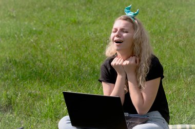 çimlerde oturan laptop ile kız