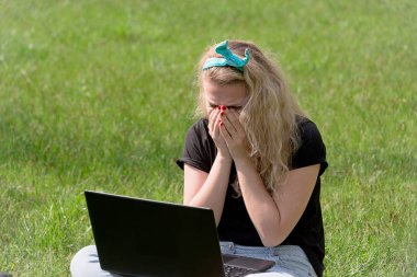 çimlerde oturan laptop ile kız