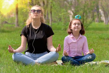 Anne ve kızı yeşil çimenlerin üzerinde dinlenmek
